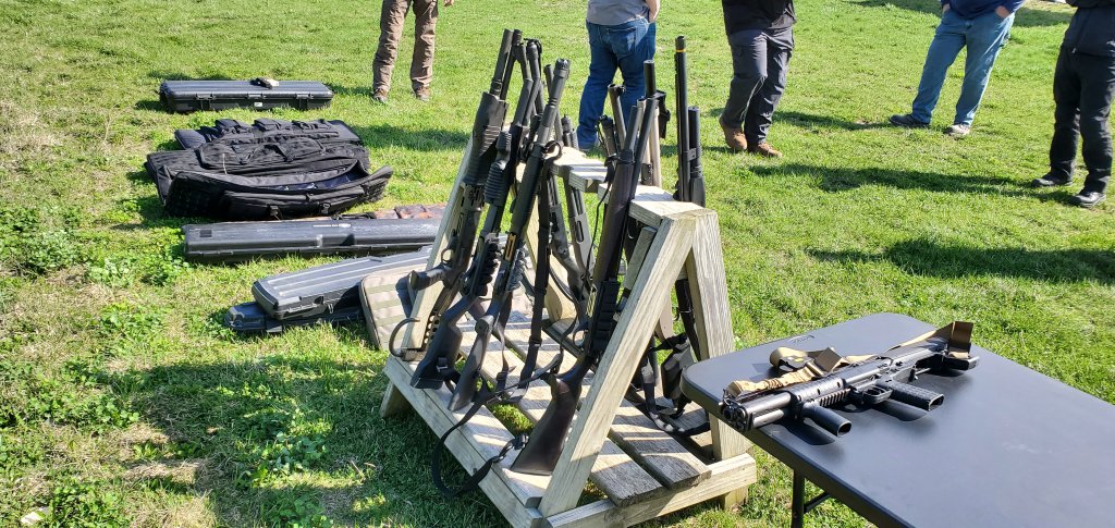 A rack of defensive shotguns and shotgun cases.